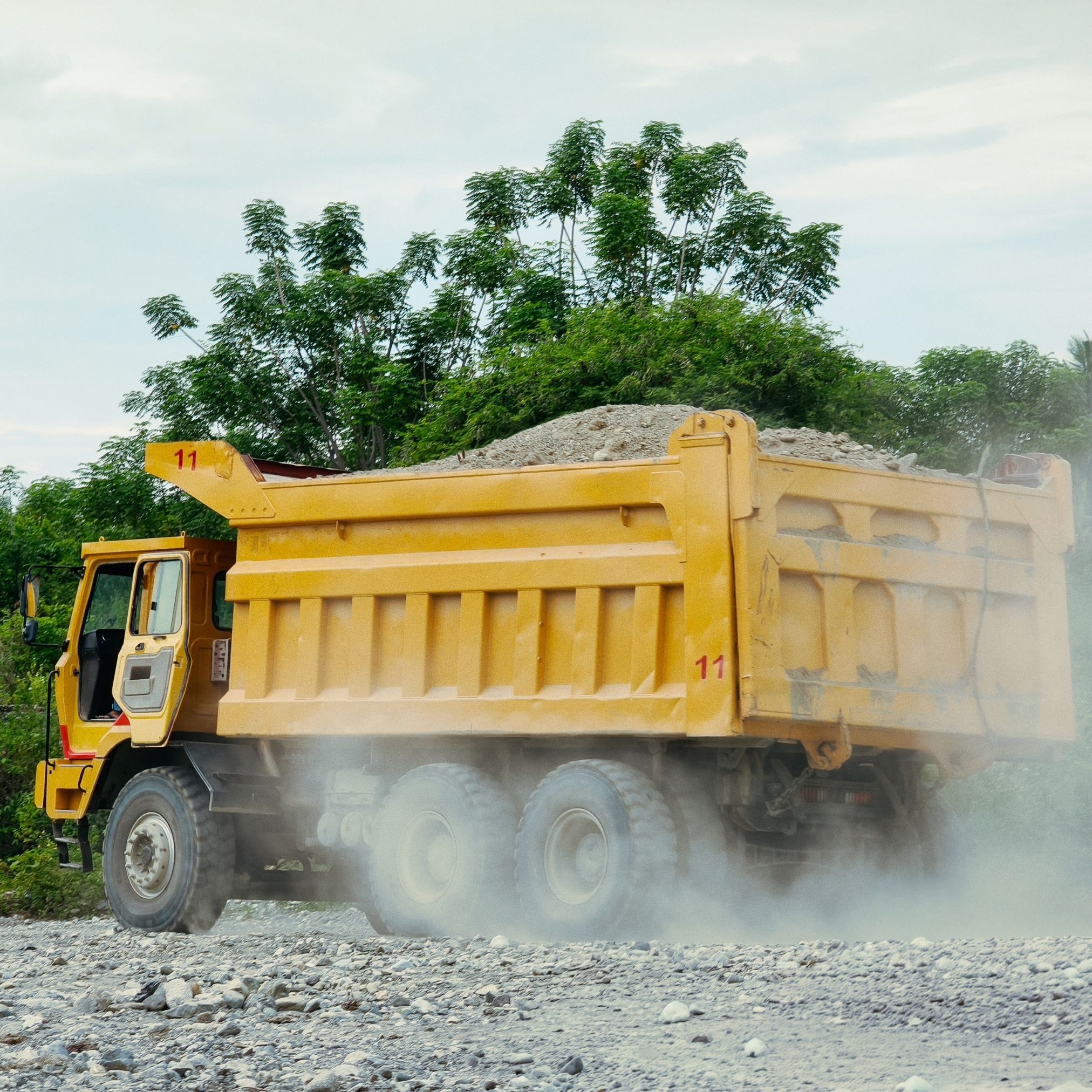 Gravel hauling truck delivering material to a construction site